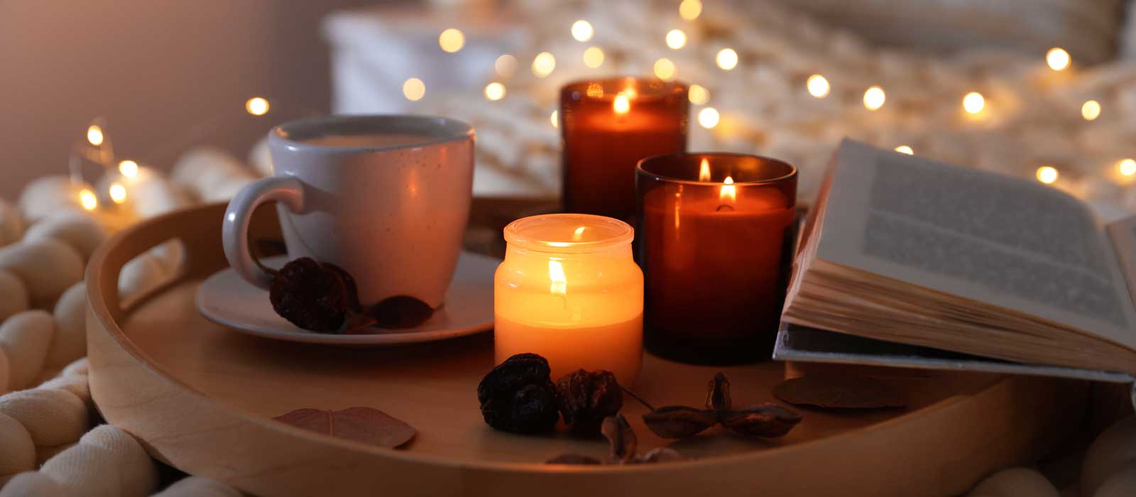 Photo of candles, tea cup, open book